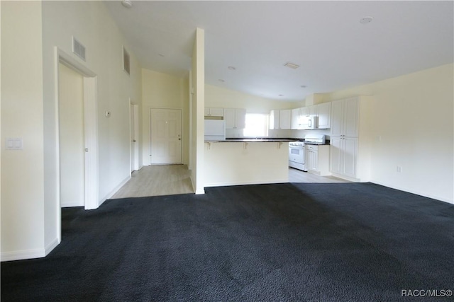 unfurnished living room featuring vaulted ceiling and light carpet