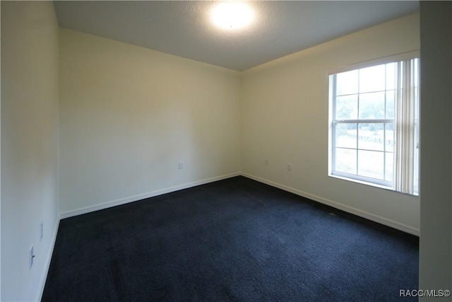 carpeted empty room with a textured ceiling