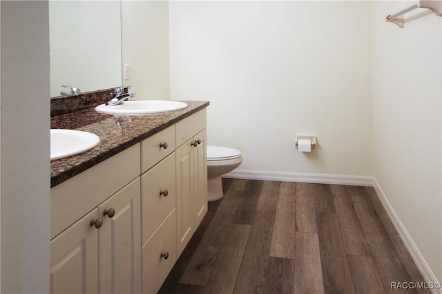 bathroom with hardwood / wood-style flooring, vanity, and toilet