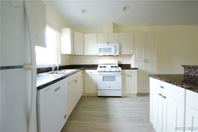 kitchen featuring sink, white appliances, dark stone counters, and white cabinets