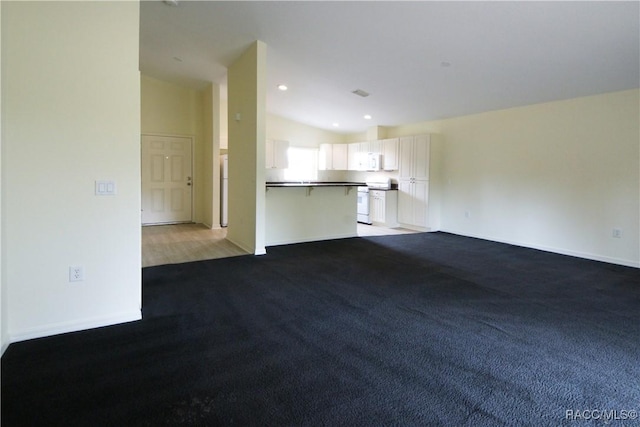 unfurnished living room with vaulted ceiling and carpet