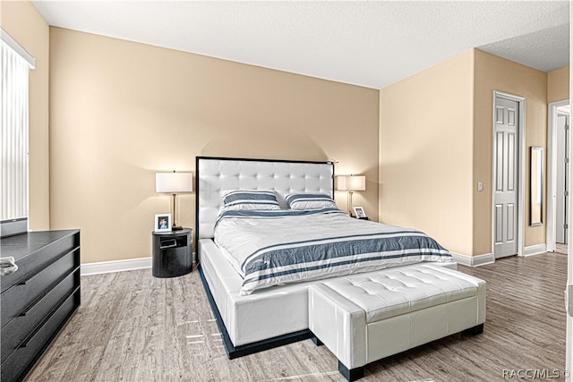 bedroom with hardwood / wood-style floors and a textured ceiling