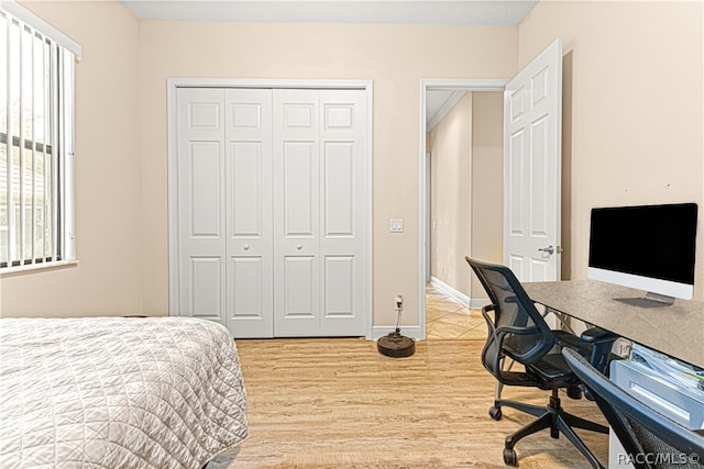 bedroom with light wood-type flooring and a closet