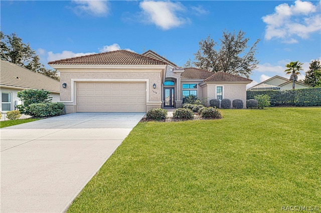 mediterranean / spanish-style home featuring a front yard and a garage