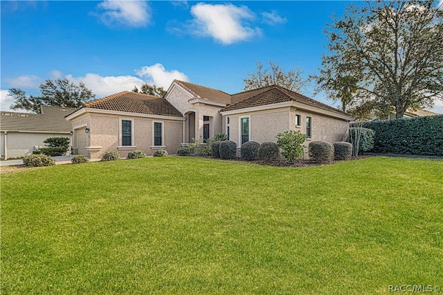 view of front of home with a garage and a front lawn