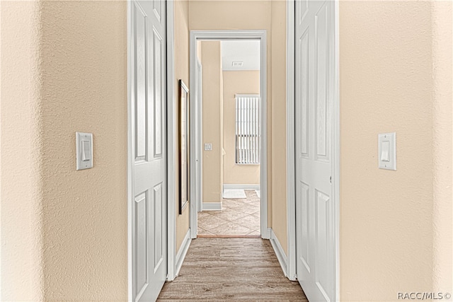 hallway with light hardwood / wood-style flooring