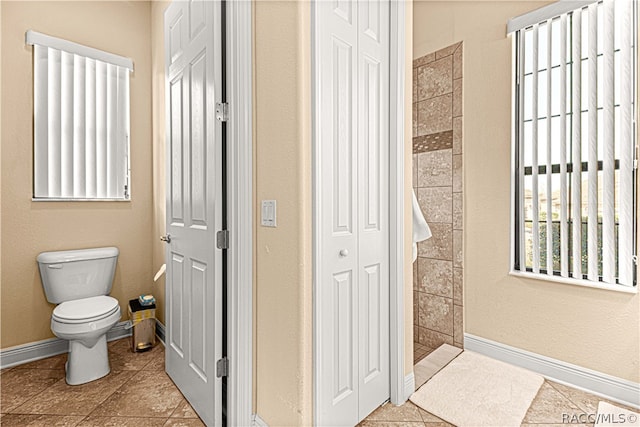 bathroom featuring tile patterned floors, toilet, and walk in shower