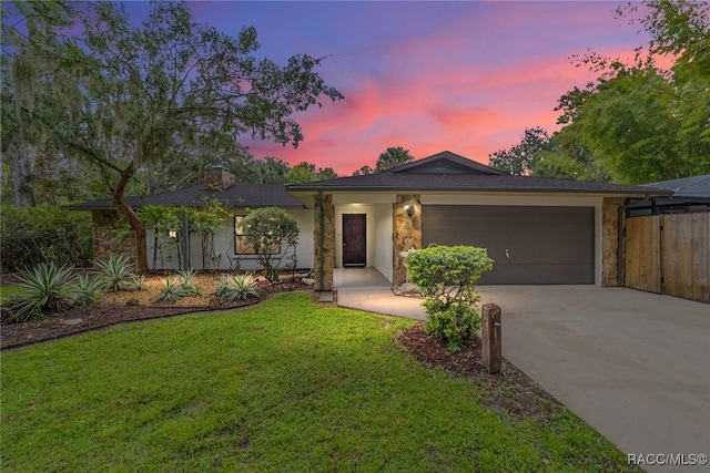 single story home featuring a lawn and a garage