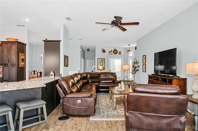 living room featuring ceiling fan and light hardwood / wood-style floors