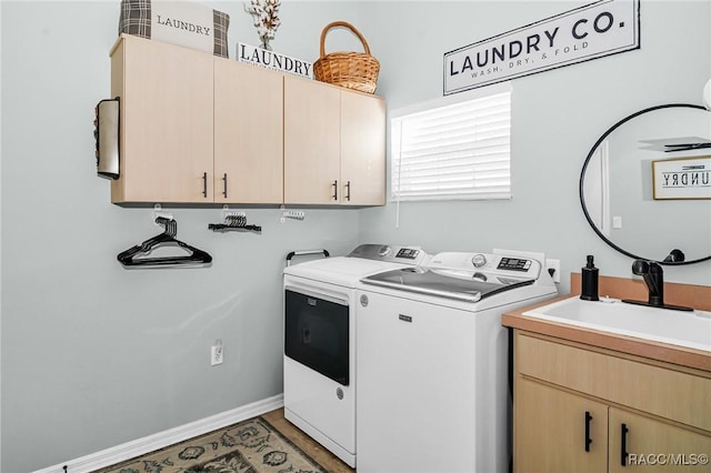 laundry area with cabinets, independent washer and dryer, and sink