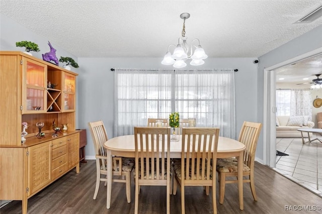 dining space featuring dark hardwood / wood-style flooring, a chandelier, and a textured ceiling