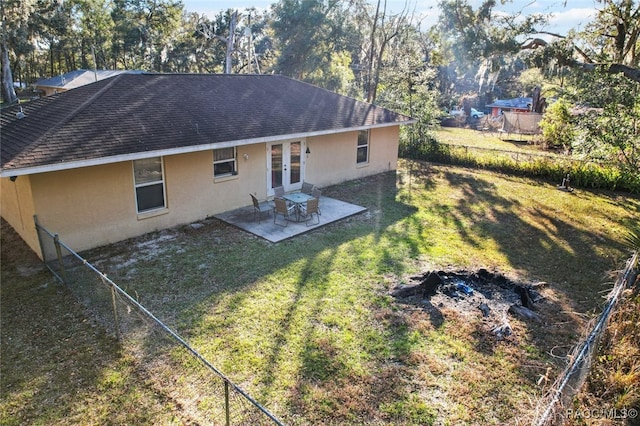 back of house with french doors, a patio, and a lawn