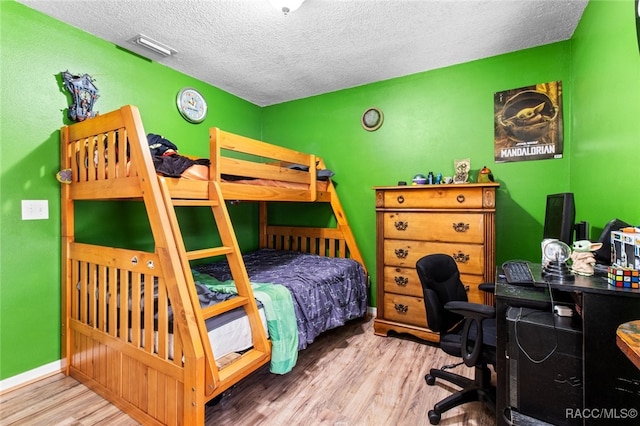 bedroom featuring wood-type flooring and a textured ceiling