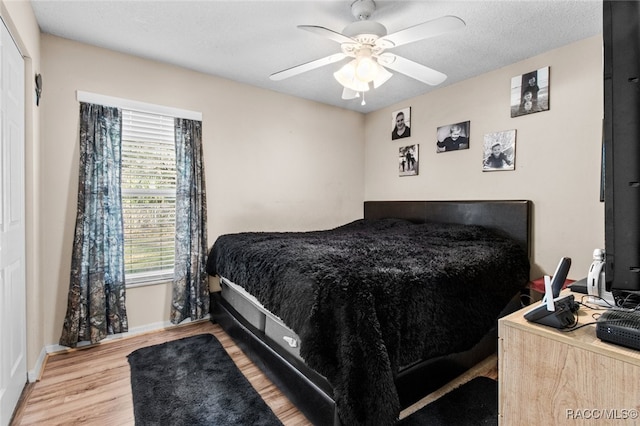 bedroom featuring a textured ceiling, light hardwood / wood-style floors, and ceiling fan