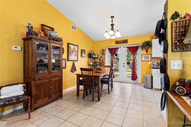 dining room featuring french doors, a chandelier, vaulted ceiling, and light tile patterned floors