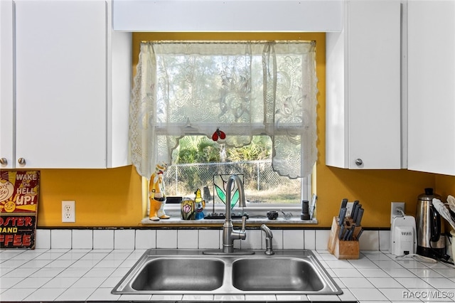 kitchen featuring white cabinetry and sink