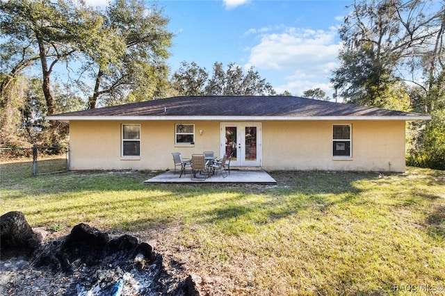 back of property featuring french doors, a patio, and a lawn