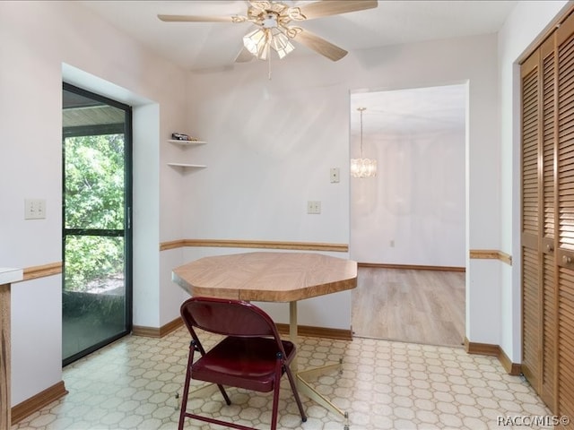 dining area with ceiling fan with notable chandelier and light hardwood / wood-style flooring