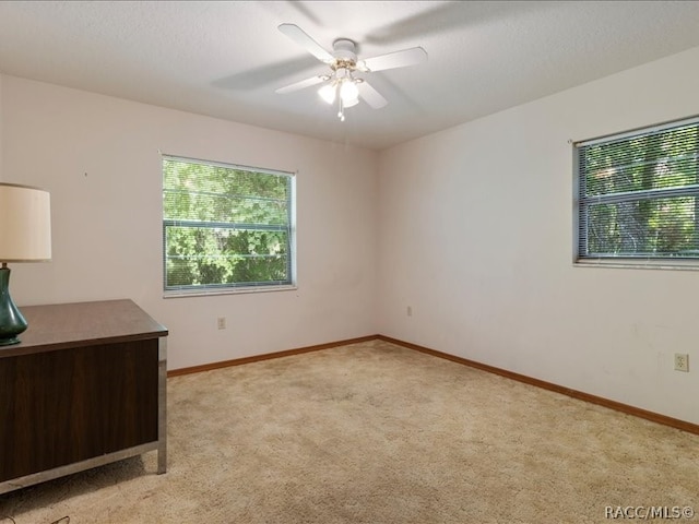 unfurnished room featuring light carpet and ceiling fan