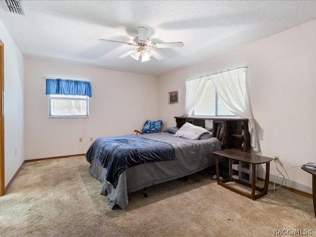 carpeted bedroom with a textured ceiling and ceiling fan