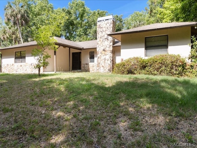 rear view of house featuring a yard