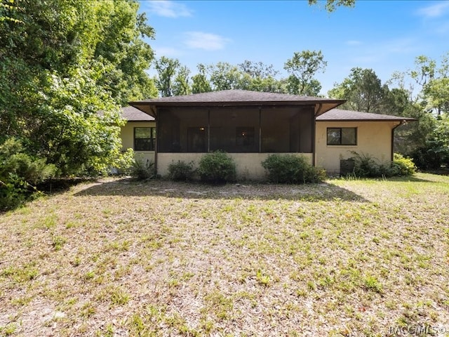 back of property featuring a yard and a sunroom