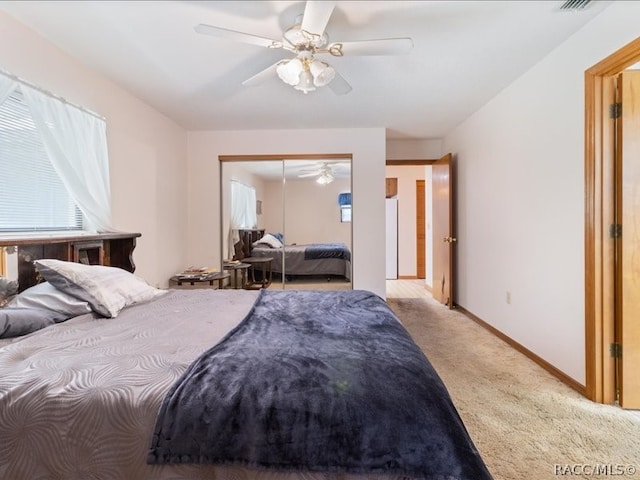 bedroom featuring ceiling fan, light colored carpet, and a closet