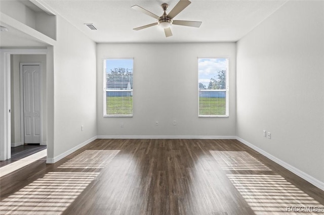 unfurnished room with visible vents, plenty of natural light, wood finished floors, and ceiling fan