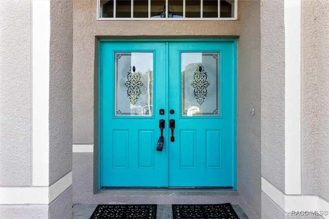 entrance to property with french doors and stucco siding