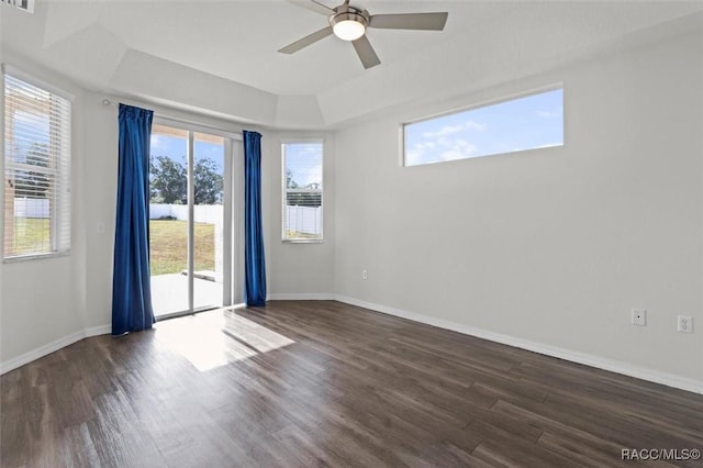 spare room with visible vents, wood finished floors, baseboards, a raised ceiling, and a ceiling fan