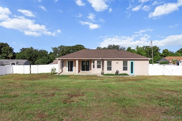 view of front of property featuring a patio, a fenced backyard, a front yard, and stucco siding