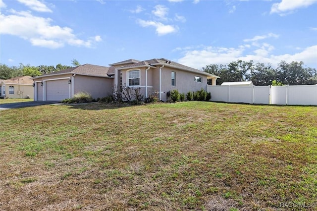 ranch-style house with driveway, fence, a front lawn, an attached garage, and stucco siding