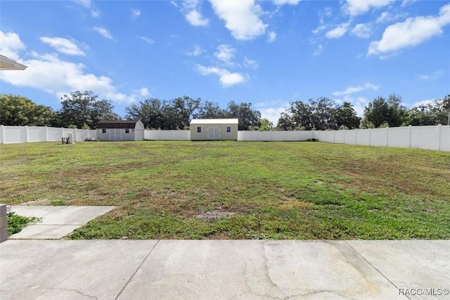view of yard with an outdoor structure, a fenced backyard, and a storage unit