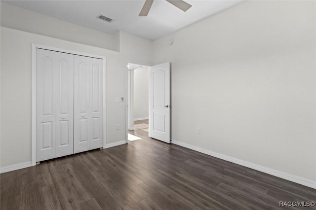 unfurnished bedroom featuring baseboards, visible vents, dark wood finished floors, and a closet