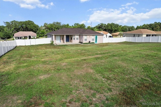 back of property featuring a lawn, a fenced backyard, and a patio area