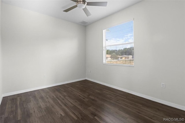 empty room with baseboards, ceiling fan, dark wood finished floors, and visible vents