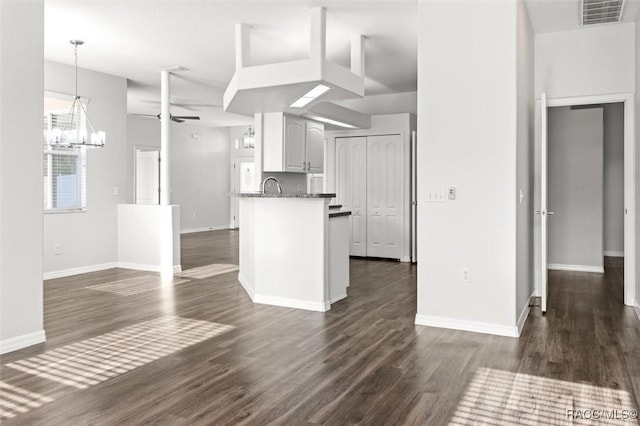 kitchen with visible vents, baseboards, dark wood-type flooring, and ceiling fan with notable chandelier
