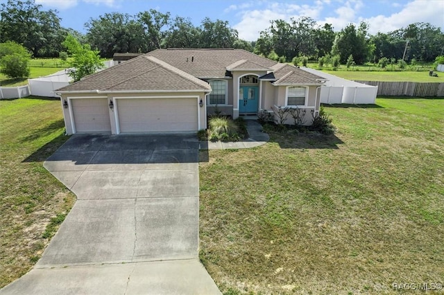 ranch-style home featuring a garage, a front lawn, fence, and driveway