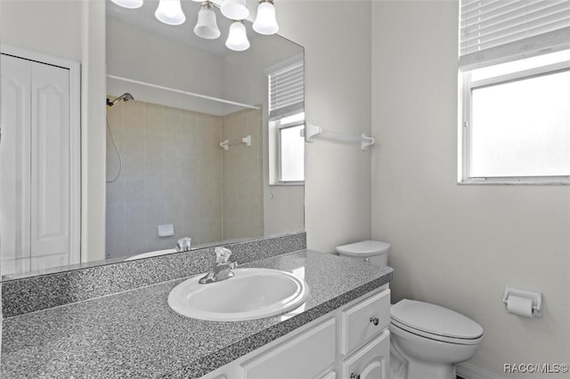 full bathroom with vanity, walk in shower, and toilet