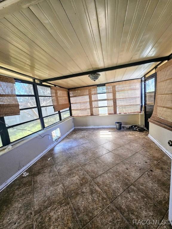 unfurnished sunroom featuring wooden ceiling