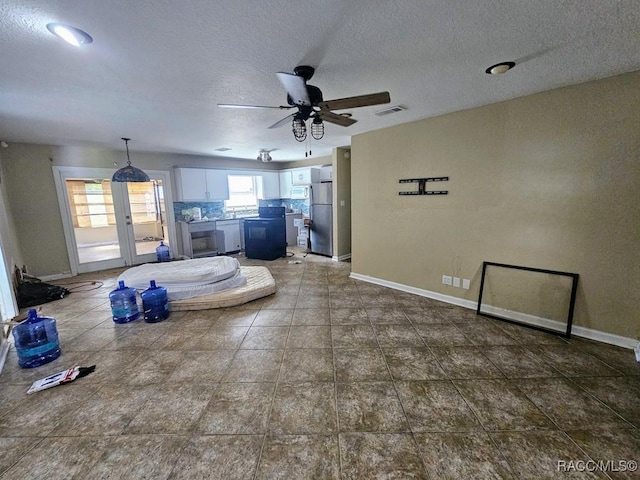 living room featuring ceiling fan and a textured ceiling