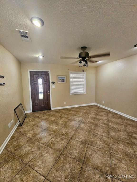 entrance foyer with ceiling fan and a textured ceiling