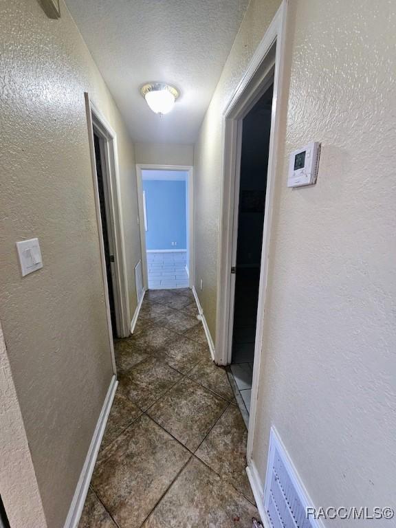 hall with a textured ceiling