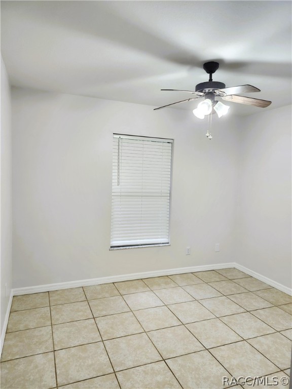 empty room featuring ceiling fan and light tile patterned flooring