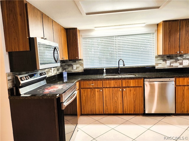 kitchen with plenty of natural light, sink, light tile patterned floors, and stainless steel appliances