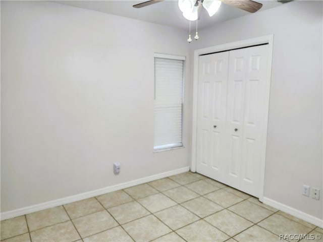 unfurnished bedroom with ceiling fan, light tile patterned flooring, and a closet