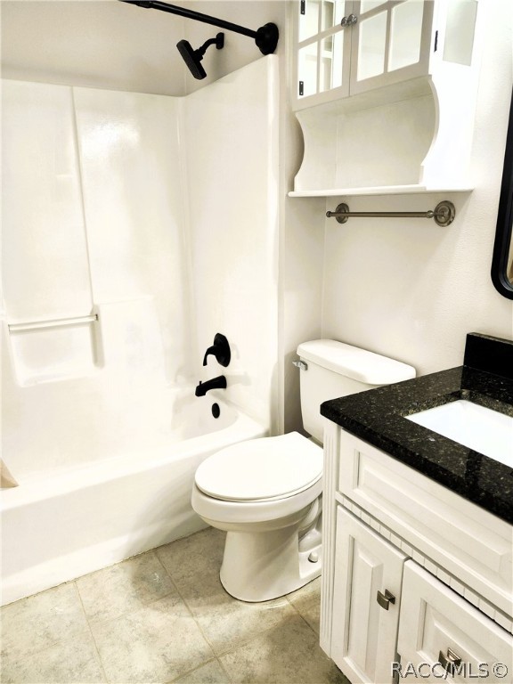 full bathroom with tile patterned flooring, shower / tub combination, vanity, and toilet