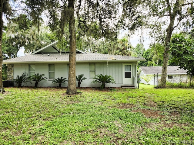 rear view of house featuring a lawn