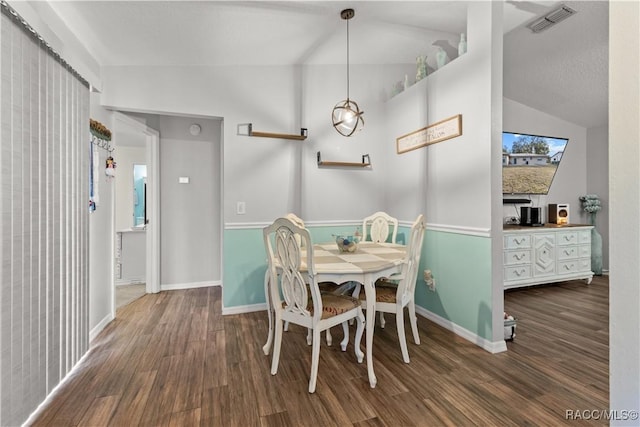 dining space featuring dark wood-type flooring and lofted ceiling