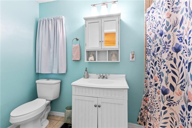 bathroom featuring curtained shower, tile patterned flooring, vanity, and toilet